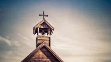Photo of wooden church against a dusty sky.