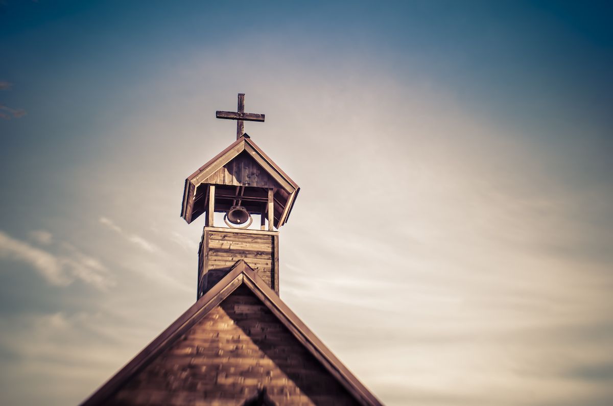 Photo of wooden church against a dusty sky.