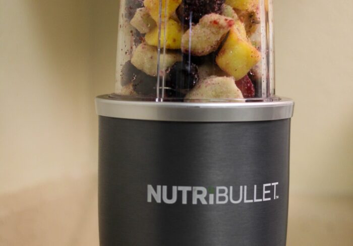 Nutribullet with a container of frozen fruit ready to be blended