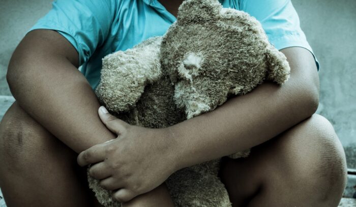 Sad boy sitting alone with old teddy bear - maclaren hall - sex abuse