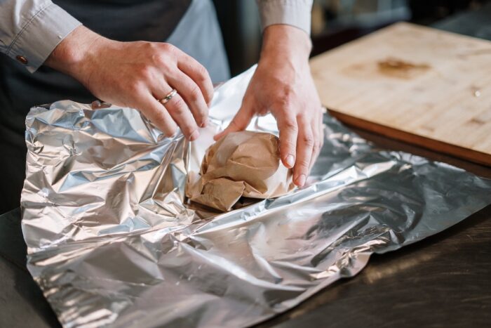 Person wrapping bread in aluminum foil - JP Morgan, Goldman Sachs, price-fixing