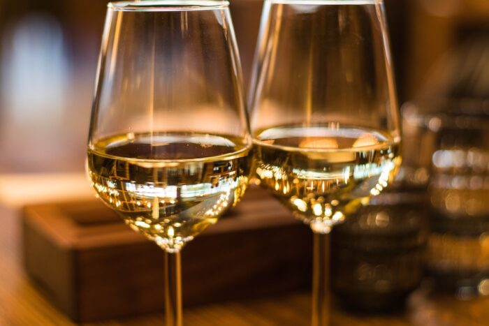 Close up of two wine glasses filled with white wine.