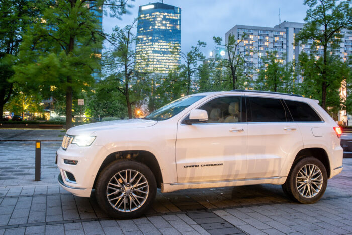 New SUV Jeep Grand Cherokee model against the background of modern buildings.