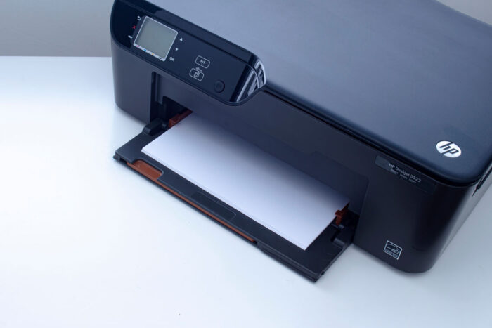 An HP Deskjet 3522 e-All-in-One Printer on a white table.