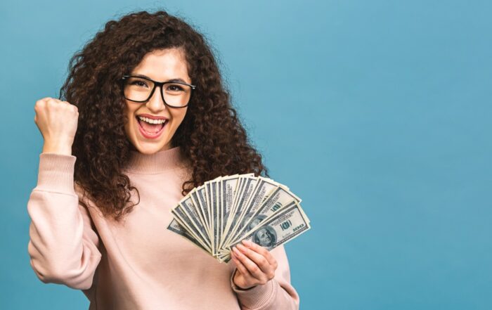 cheerful young woman holding money