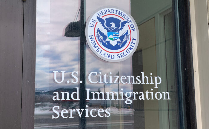 Close of up U.S. Citizenship and Immigration Services door with logo.