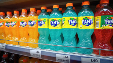 Fanta in plastic bottles display on shelf for sale in supermarket.