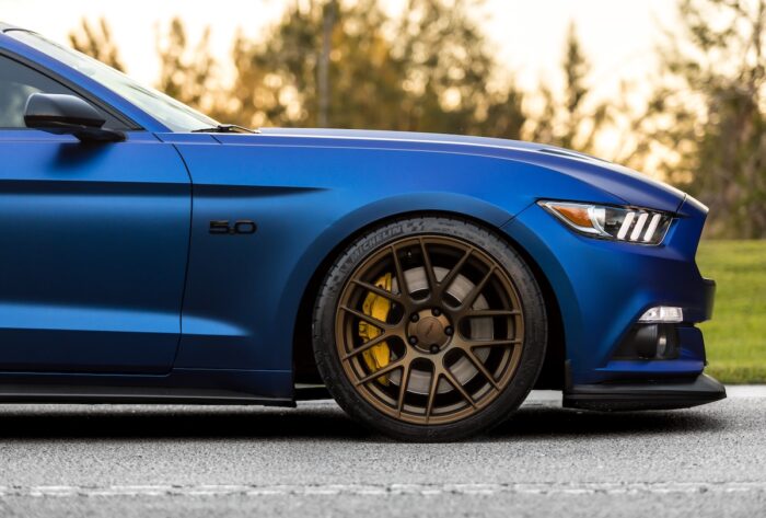 2020 Blue Ford Mustang from the side with trees in the background- recall, powertrain