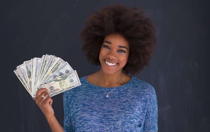 Portrait of a beautiful smiling afro american woman holding money