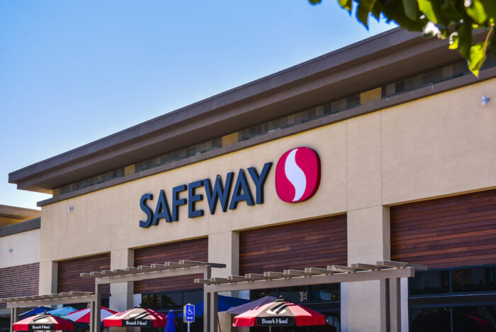 Exterior of a Safeway store against a blue sky.