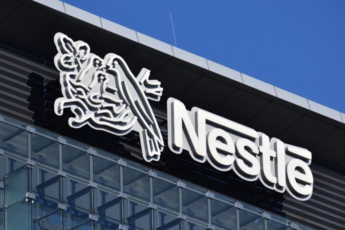 Close up of Nestle signage on a building against a blue sky - Nestlé class action, slave labor