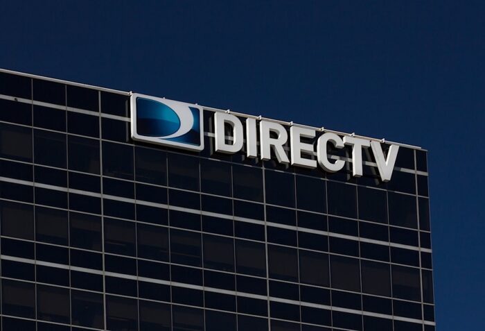 DirecTV corporate headquarters building against a dark blue sky.