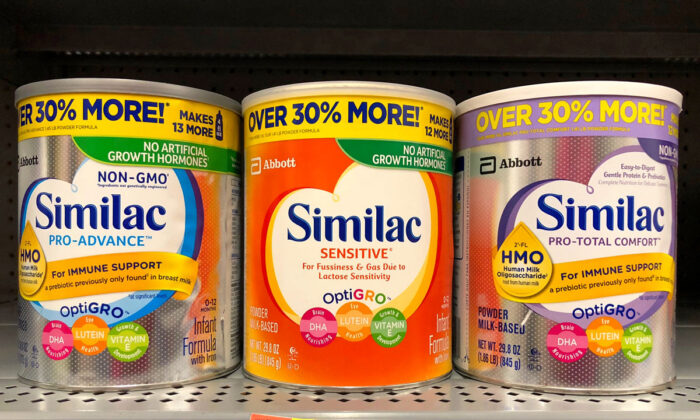 Grocery store shelf with containers of Similac brand powdered formula.