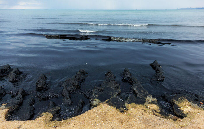 The sea and the beach are polluted with oil. A crude oil spill on the sand of a city beach - santa barbara pipeline