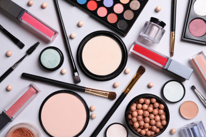 Composition with different cosmetic products on light grey background, top view.