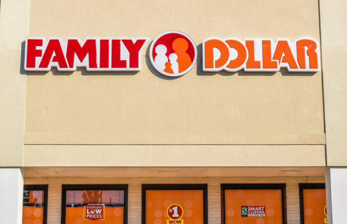 Closeup of "Family Dollar" discount store chain's exterior facade brand and logo signage in red and orange letters on a sunny day.