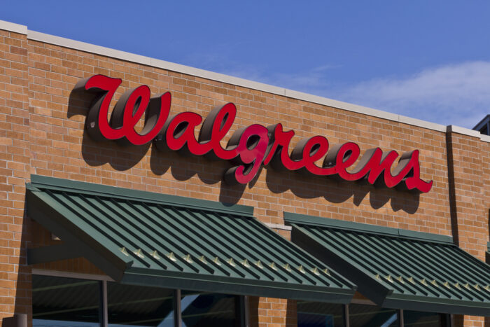 Exterior of a Walgreens store against a blue sky. Close up of store signage.