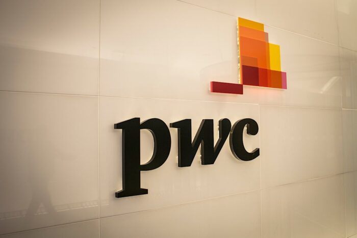 Close up of PWC signage against a white glossy wall.