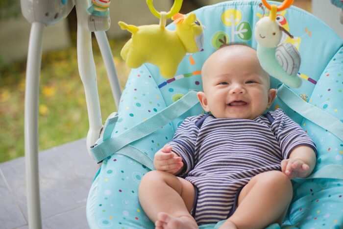 A happy baby in a rocker - 4moms recall