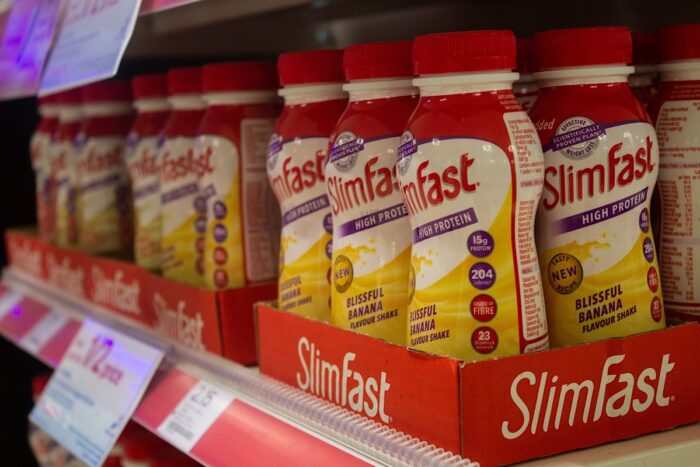 Slim Fast products on a shelf in a pharmacy store.