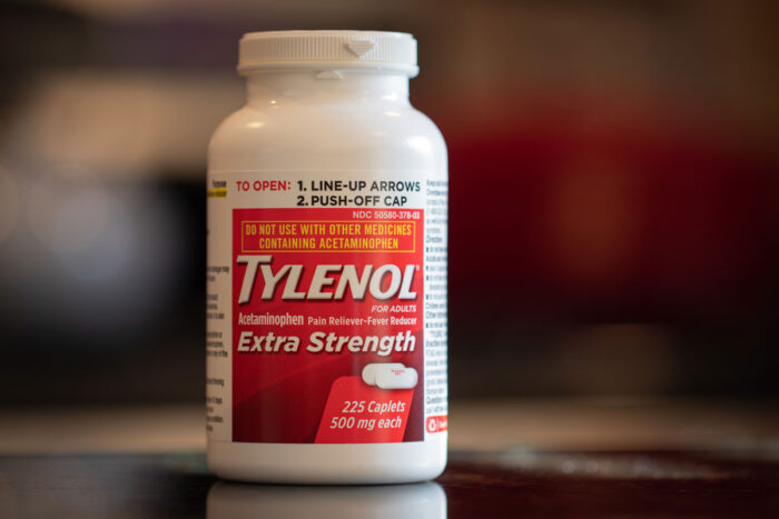 Bottle of Adult Tylenol Extra Strength with a blurry background.