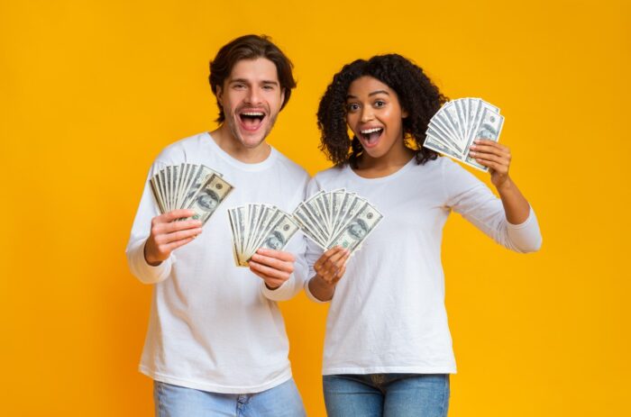 Happy guy and girl holding lot of cash in hands