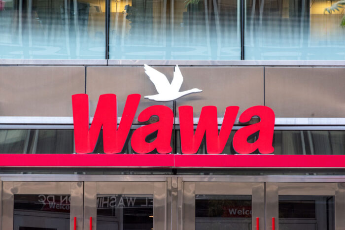 Sign on storefront entrance of Wawa convenience store in downtown Washington - wawa data breach settlement