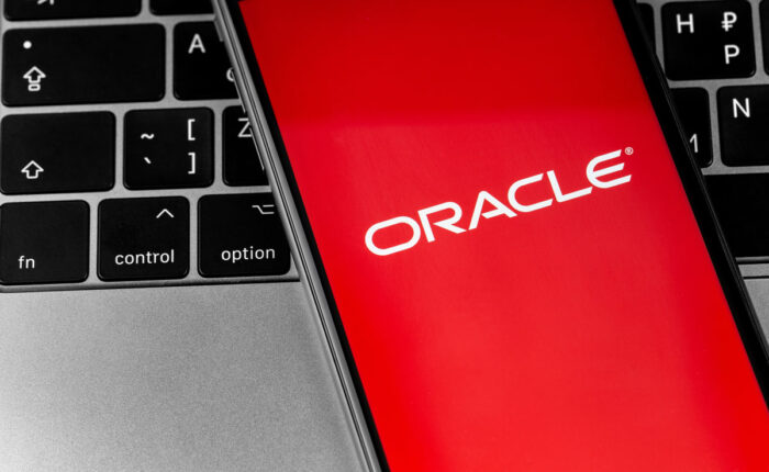 Oracle logo app on the red screen smartphone with keyboard closeup, representing the Oracle America Inc. class action alleging the company sells personal information to third parties.