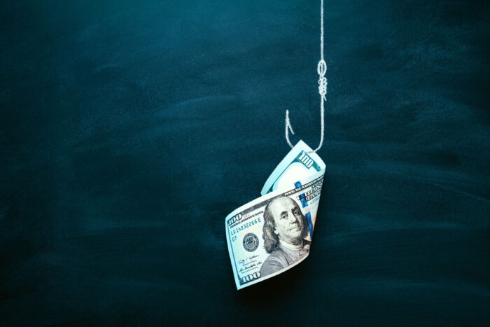 $100 bill on a fishing hook against a dark blue background. sweepstakes scam concept - ftc next-gen refund