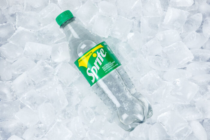 Sprite soft drink in a plastic bottle on ice cubes.