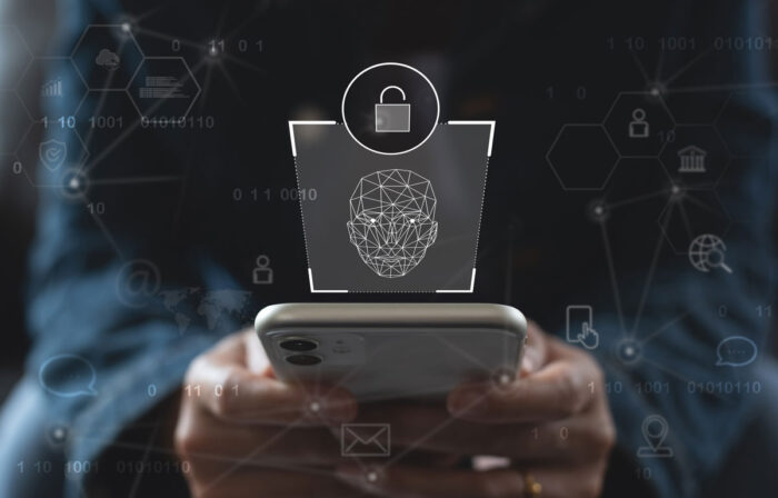Close up of hands holding a smartphone with a facial recognition overlay. Verify identity conceptn - BIPA