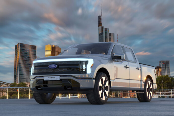 Photo of Ford F-150 Lightning against a city background.