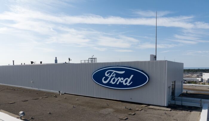 The Ford Motor Co. logo is seen atop its Canada headquarters office building - antitrust settlement - class action lawsuit ford - vehicle exporting
