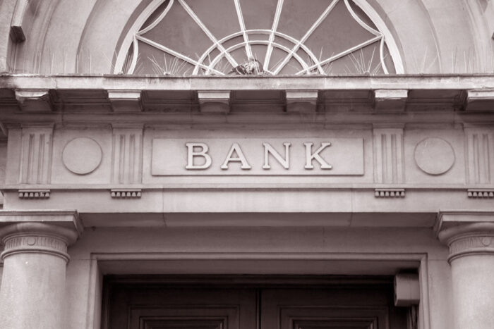 Close up of a bank sign above a bank entrance.