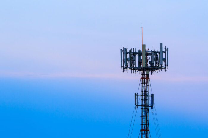 Mobile phone Telecommunication Radio antenna Tower against a dusky blue sky.