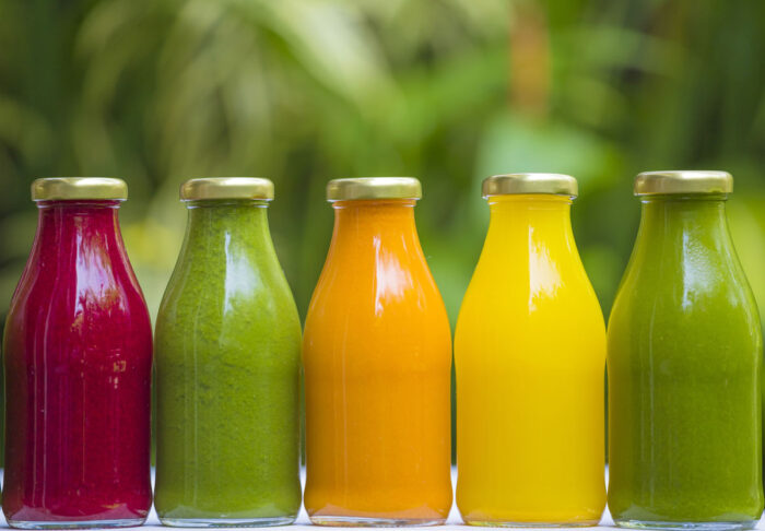 Organic cold-pressed raw vegetable juices in glass bottles.