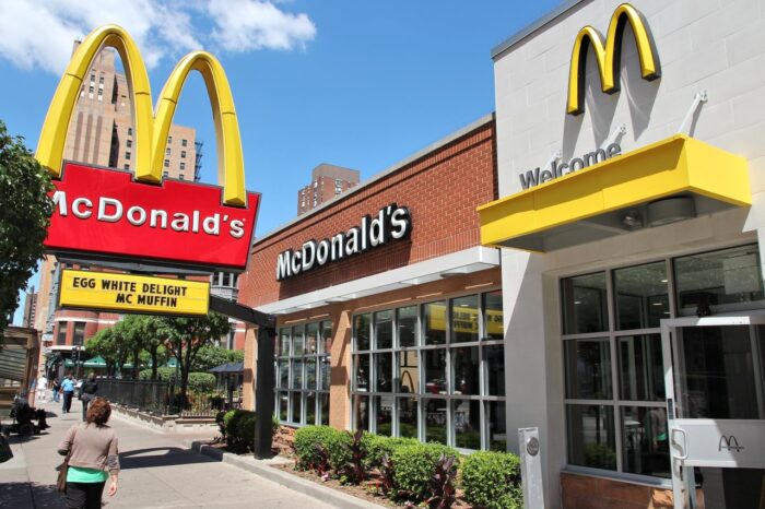 People walk by McDonald's restaurant in Chicago. mcdonald's settlement over BIPA violation