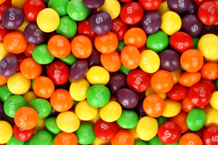 Skittles multicolored fruit candies background - titanium dioxide class action