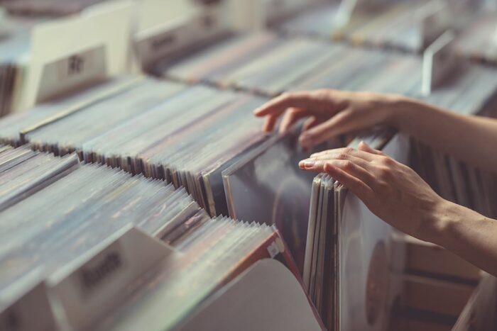 A pair of hands browse records in a vinyl record store, representing the Audiophile Music Direct and Mobile Fidelity Sound Lab class action.