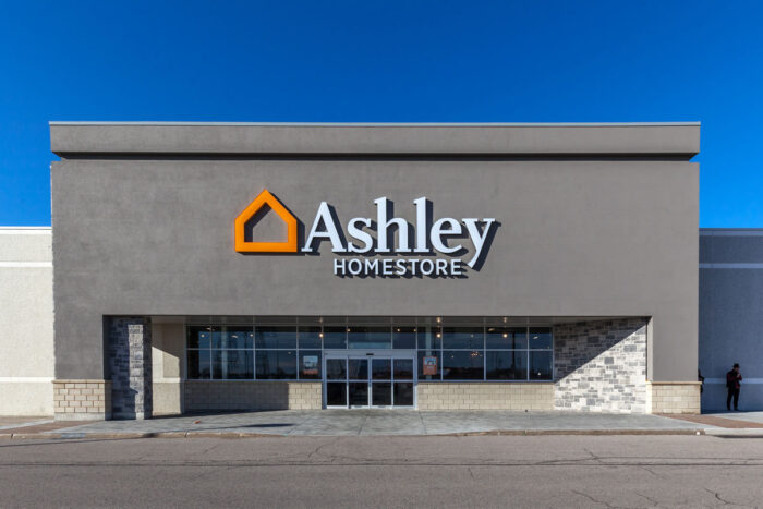 Ashley HomeStore storefront against a blue sky.