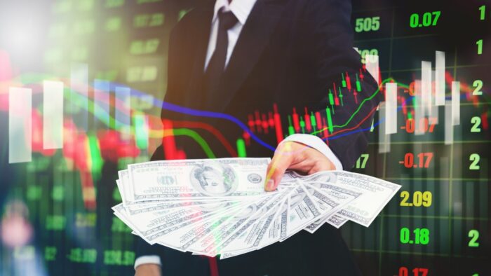Businessman Holding money US dollar bills on digital stock market financial exchange information and Trading graph background, Bank antitrust stock loan concept