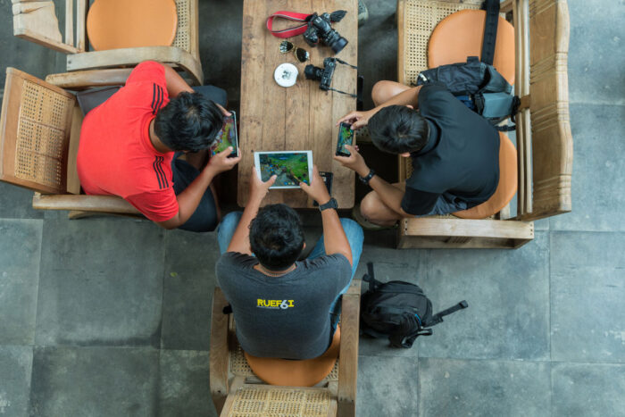 Top view of Undefined men using the ipad and iphone playing a video game.