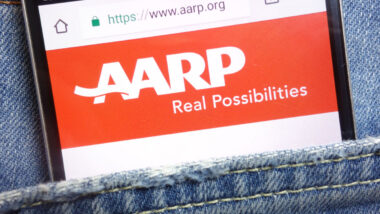 AARP (American Association of Retired Persons) website displayed on smartphone hidden in jeans pocket.