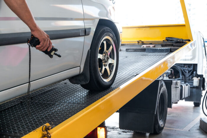 Close up of vehicle being loaded onto flatbed tow truck - Arkansas Federal Credit Union repossessions, auto