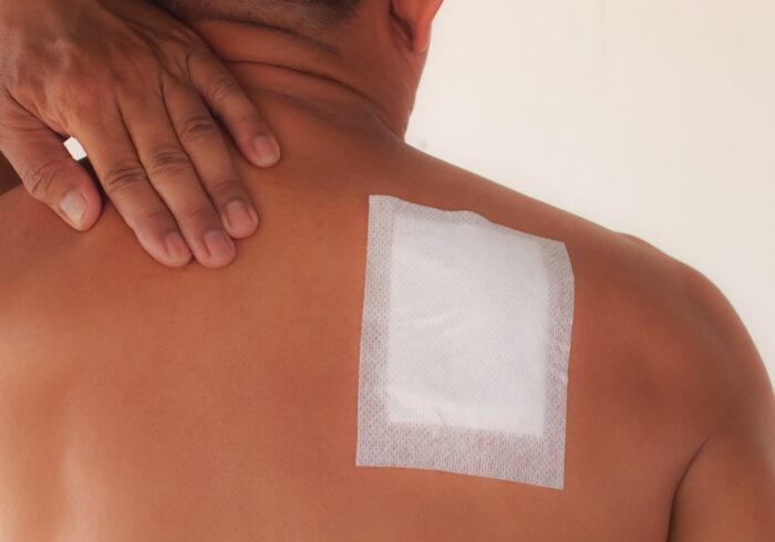 Medicated Lidocaine pain relief patch therapy with senior business man pain shoulders