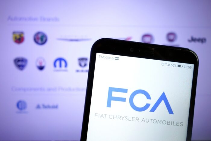 Fiat Chrysler Automobiles FCA logo displayed on mobile phone - FCA settlement, jeep class action lawsuit