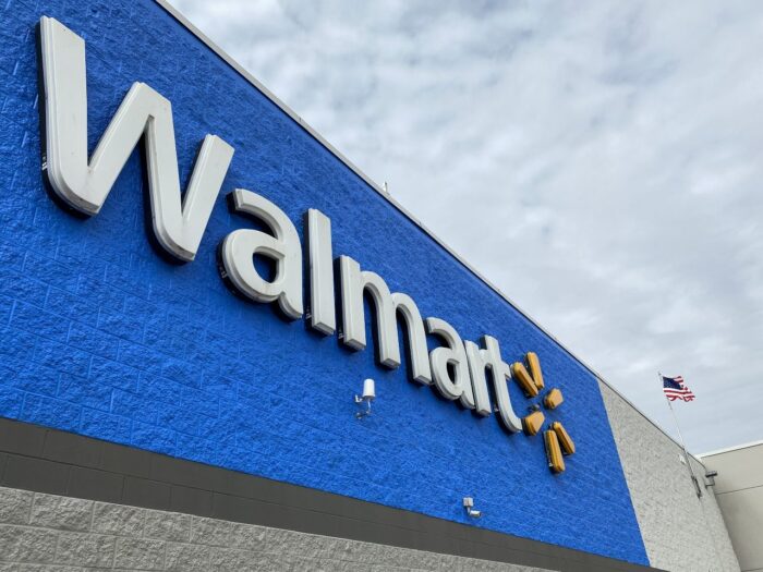 Walmart logo and name on building with blue background.