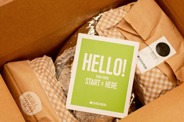 Hello Fresh meal kits in a cardboard box with Hello brochure