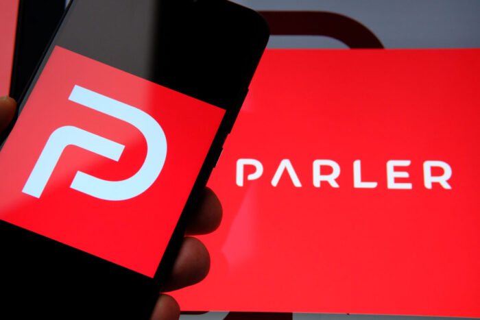 "Parler app" logo seen on the screen of smartphone and on the blurred background.