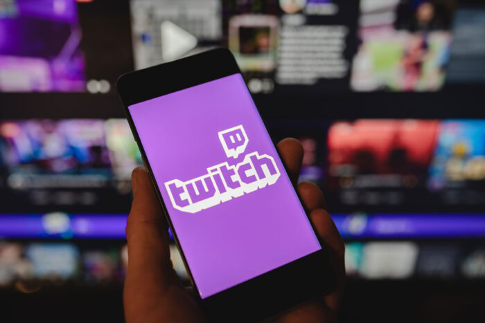Twitch logo on smartphone in hand and the official website.